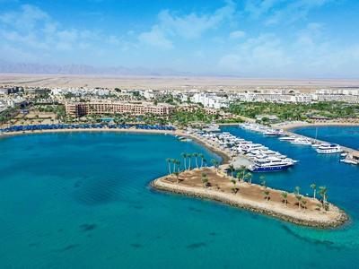 Veduta aerea di un'area portuale con acqua azzurra limpida e barche lungo la riva.