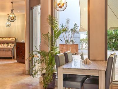 Moderní hotelová oblast se stoly, židlemi a rostlinami.