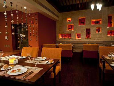 Intérieur chaleureux de restaurant avec murs marron, décoration suspendue et tables bien dressées.