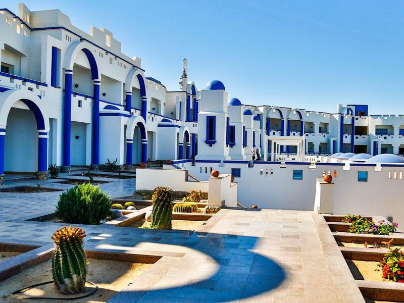 Hotel bianco e blu in stile mediterraneo con terrazza sotto un cielo limpido