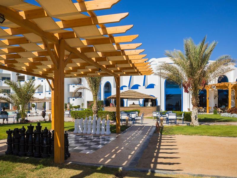 Area ricreativa con scacchi all'aperto sotto una tettoia in legno in un resort soleggiato