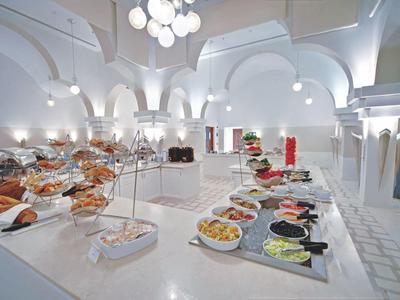 Licht buffet in een ruime eetzaal met elegante bogen en witte inrichting.
