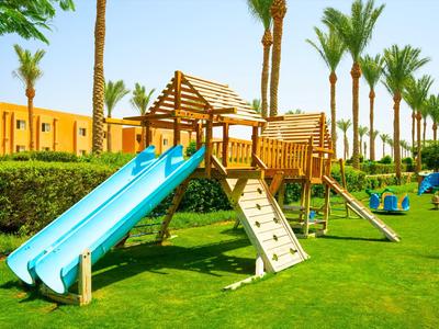 Area giochi per bambini con scivoli e struttura arrampicata su prato erboso in hotel al sole.