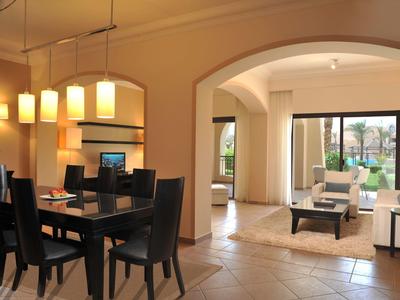 Spacious, modern living and dining area with natural light and tan tile flooring.
