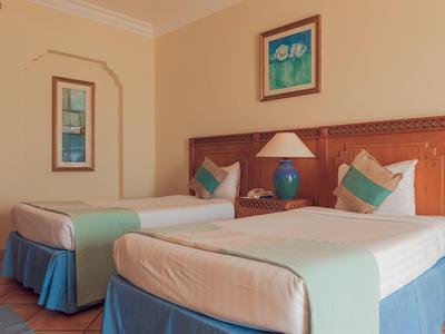 Dvoulůžkový pokoj s modrými a zelenými akcenty v hotelu.