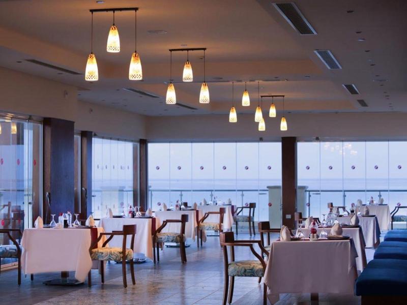 Elegant restaurant dining area with white tablecloths and hanging pendant lights.