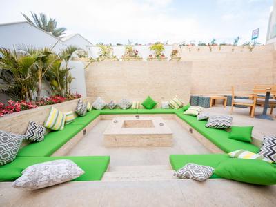 Ogród z zielonymi poduszkami i poduszkami wokół centralnego paleniska.