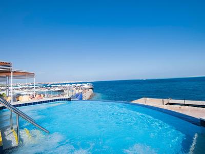 Wanna z hydromasażem z widokiem na morze pod czystym, niebieskim niebem.