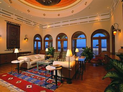 Lavish hotel lobby with grand dome ceilings and central decorative water fountain.