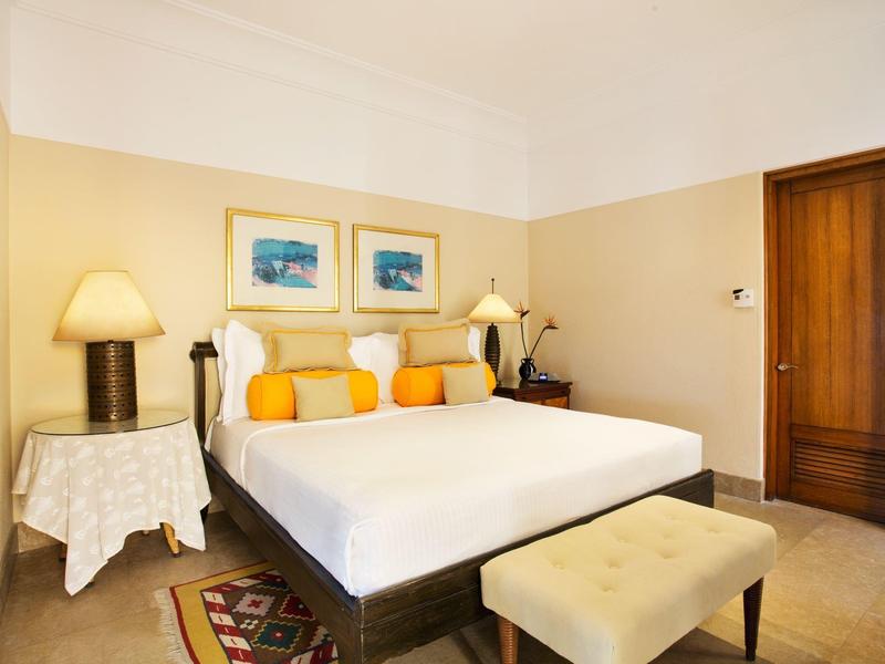 Cozy hotel room with a large bed, bedside lamps, and framed artwork on the wall.