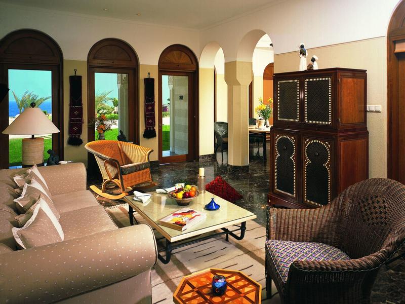 Elegant living room with arched windows, comfortable seating, and a central coffee table with decor.