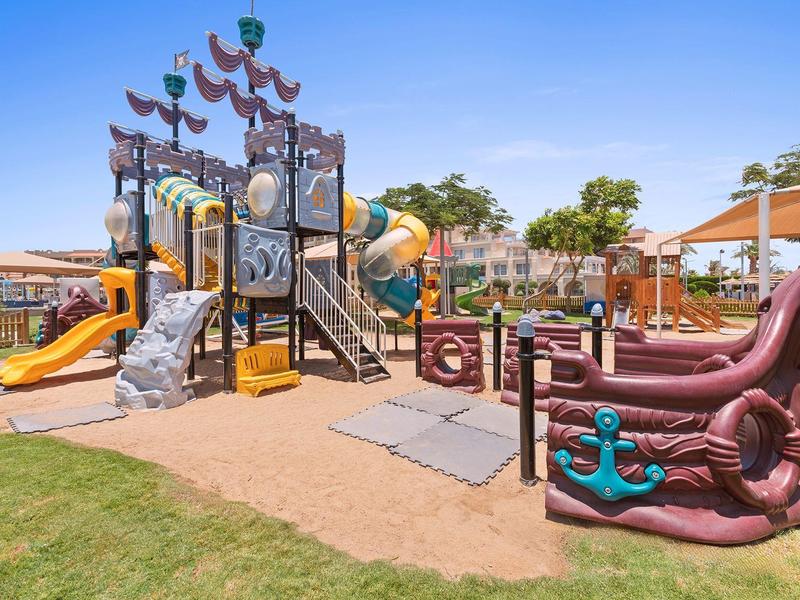 Bunter Piratenspielplatz mit Rutschen, Klettergerüsten und dekorativen Schiffselementen im Freien.
