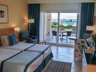 Hotel room with two beds, balcony, and sea view