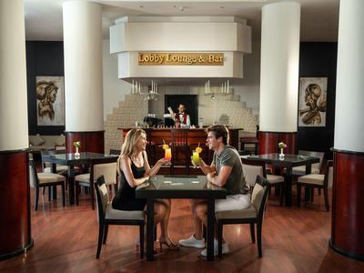 Couple sits in a stylish restaurant, conversing by candlelight at a table.