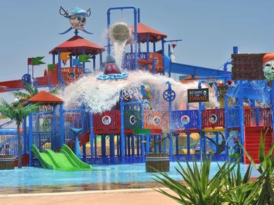 Buntes Wasserspielplatz mit Rutschen, Wasserfällen und kindgerechten Attraktionen bei klarem Himmel.