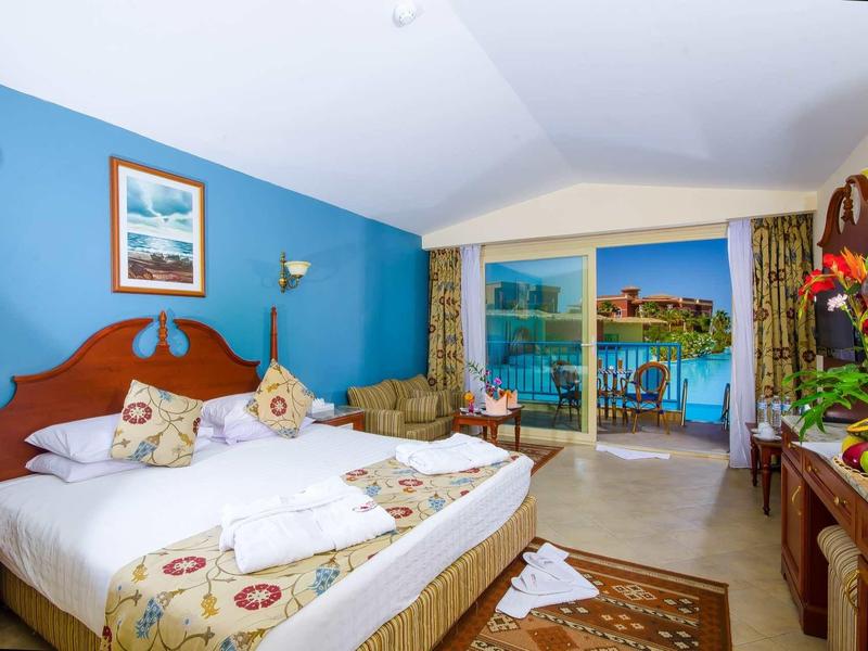 Chambre d'hôtel confortable avec grand lit et balcon donnant sur le lac.