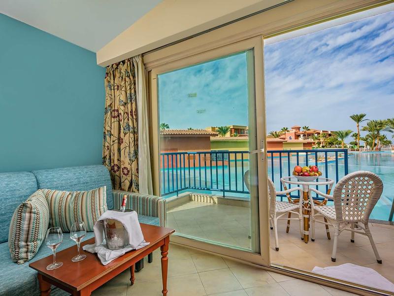 Salon d'hôtel confortable avec vue sur le balcon et le paysage aquatique.