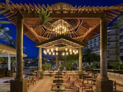 Avond open terras van een restaurant met houten meubels en sfeerverlichting.