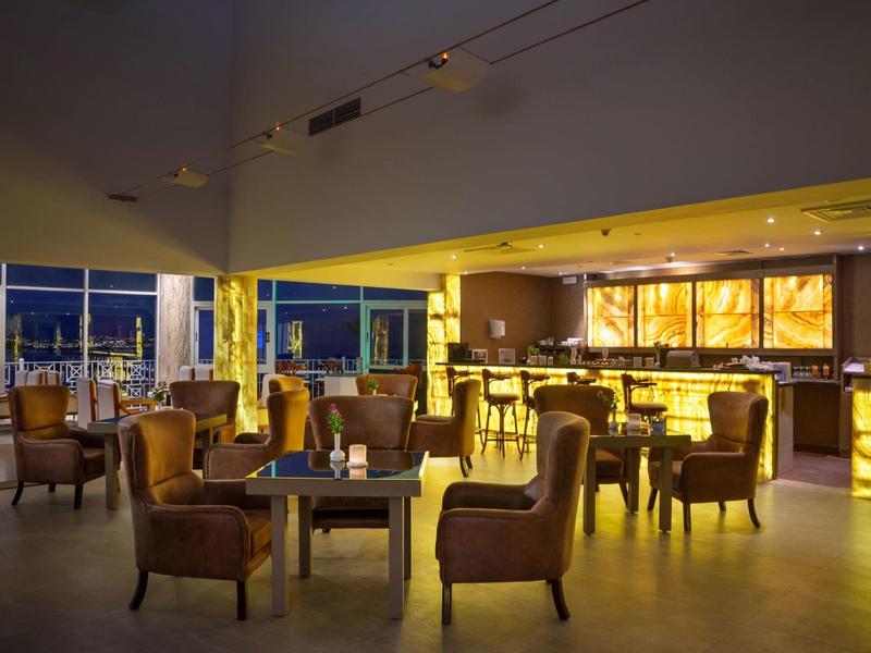 Elegantní hotelový bar s teplým osvětlením a pohodlnými koženými křesly večer.