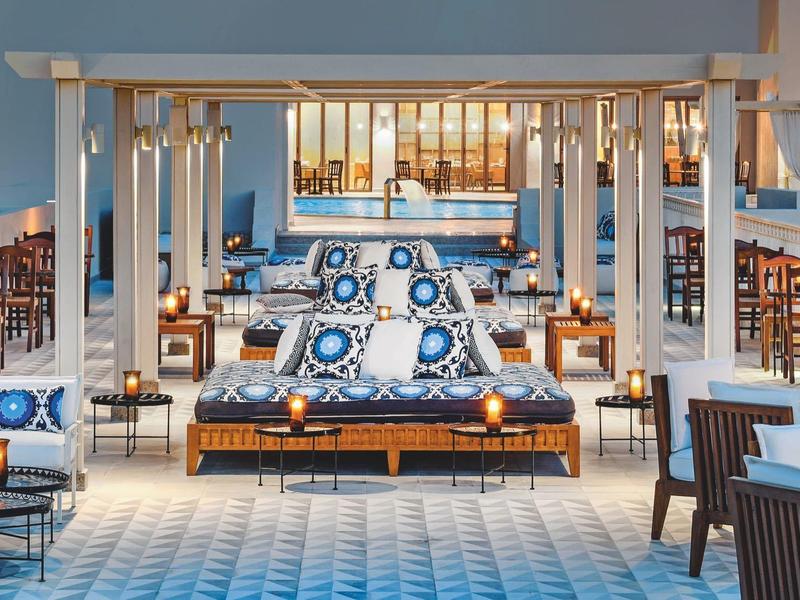 Spacious hotel dining area with stylish blue and white decor and wooden beams.