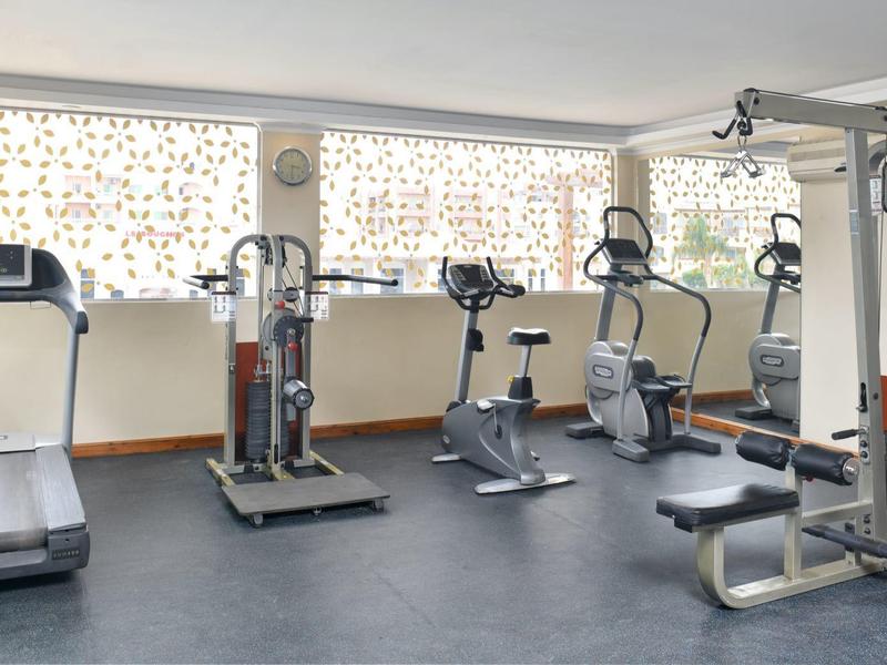 Posilovna s běžeckým pásem, rotopedy a posilovacími stroji.