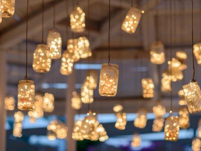 De nombreux bocaux lumineux pendent du plafond dans une pièce chaleureusement éclairée.