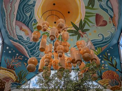 Kleurrijk plafond met onderwater thema en hangende bolverlichting in een lichte ruimte