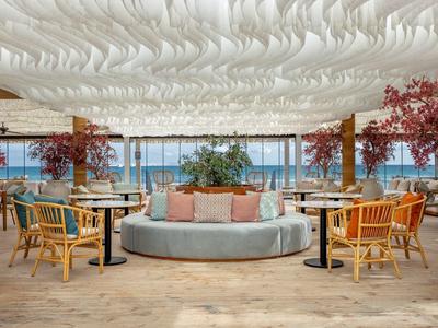 Lichte lounge met comfortabele zitplaatsen en uitzicht op zee.