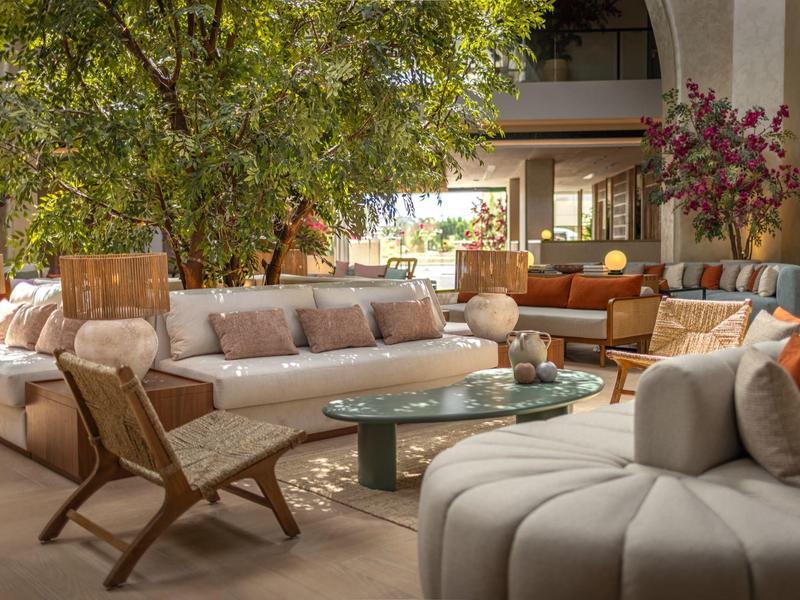 Gezellige hotelloungeruimte met banken, fauteuils en veel natuurlijk licht.