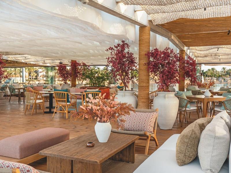 Gezellig buitengedeelte van een hotel met tafels, stoelen en herfstdecoratie.