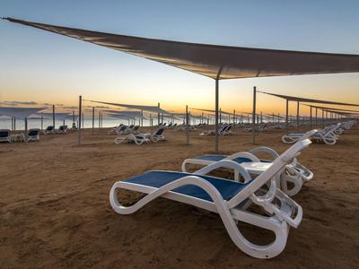 Luxuriöse Hotelanlage mit Pool und Meerblick bei Sonnenuntergang.