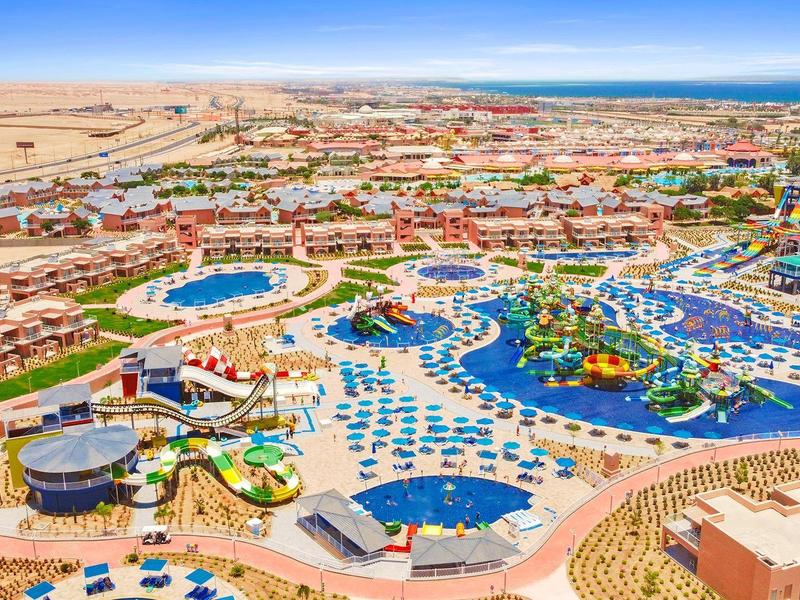 Duży ośrodek z parkiem wodnym, basenami, zjeżdżalniami i leżakami niedaleko pustyni i wybrzeża oceanu.