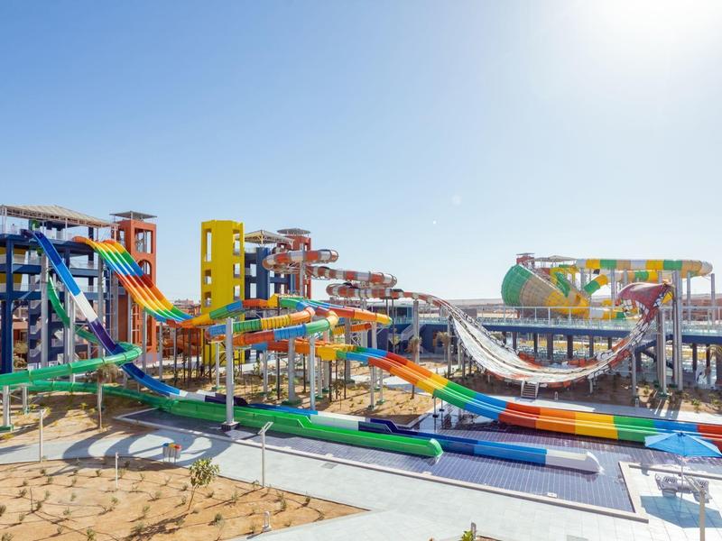 Kolorowy park wodny ze zjeżdżalniami i basenami przy plaży w słoneczny dzień