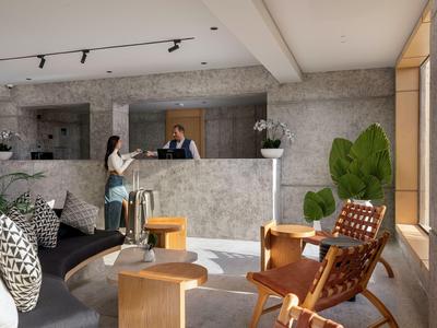 Hall d'hôtel moderne avec réception, espace de détente et grandes fenêtres laissant entrer la lumière naturelle