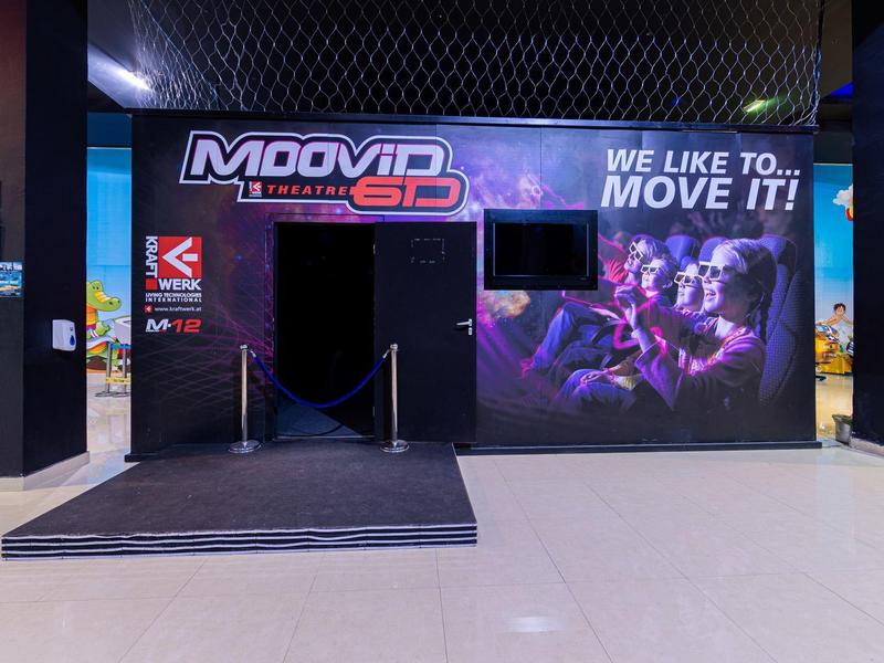 Entrance to a Moovid 5D cinema with illuminated logo and movie posters.