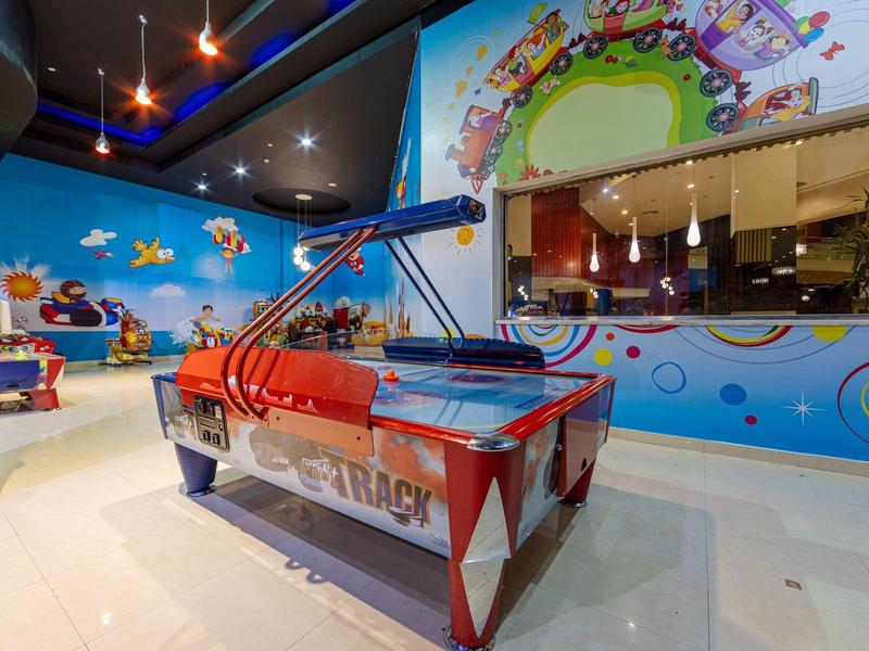 Children's play area with a red bumper car and colorful wall decorations.