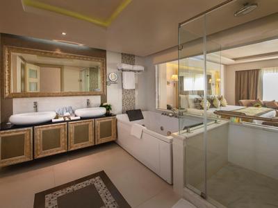 Modernes Badezimmer mit großer Badewanne, Doppelwaschbecken und Glasscheibe zur Dusche.