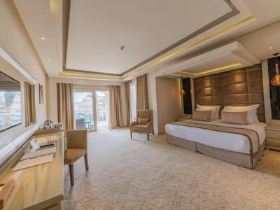 Großes, helles Schlafzimmer mit Doppelbett, Teppichboden, Schreibtisch und Balkon mit Blick.