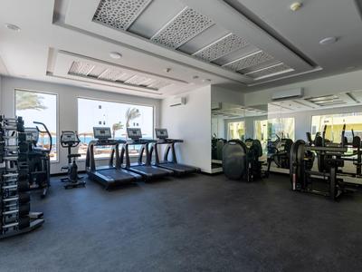 Gimnasio moderno con equipo de ejercicio y grandes ventanas en un hotel.