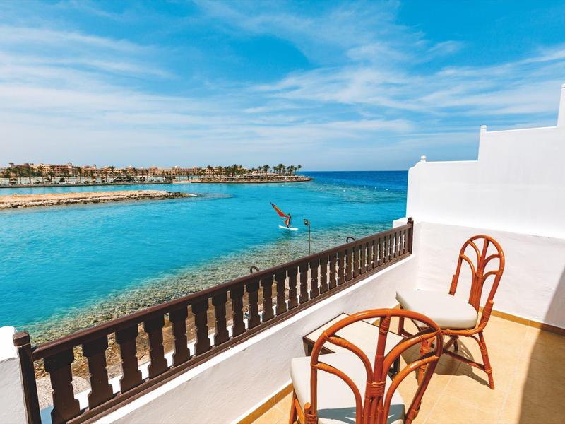 Balkon mit zwei Stühlen und Blick auf das blaue Meer und den Himmel.