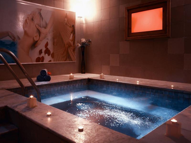 Beleuchteter Whirlpool in einer ruhigen, stimmungsvollen Umgebung mit Kerzenlicht.