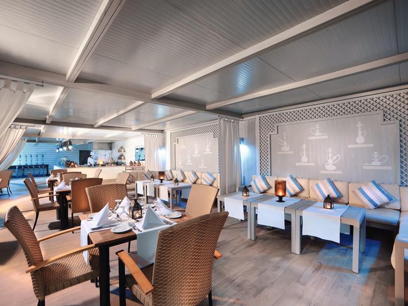 Modern eingerichteter Gastraum mit gemütlichen Sesseln, Tischen und dezenter Beleuchtung.