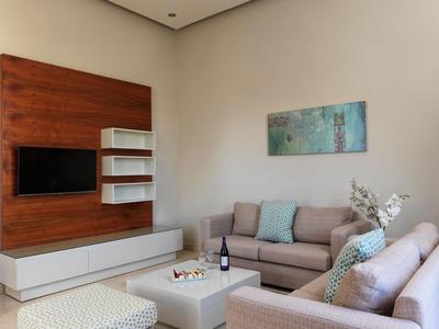 Modernes Hotelzimmer mit zwei Sofas, Holzverkleidung, TV und Dekoration.