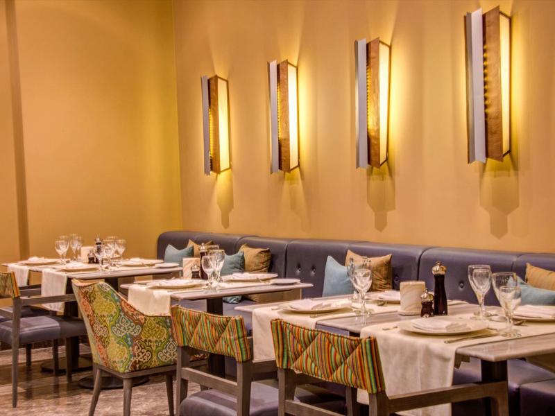 Cozy restaurant with warm yellow lighting and patterned chairs.