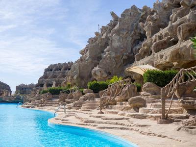 Obszar basenu z architekturą skalną i wieloma poziomami obok czystej błękitnej wody