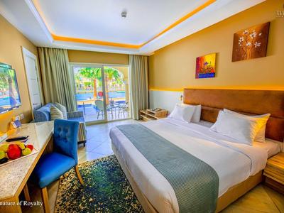 Chambre d'hôtel lumineuse avec grand lit double, bureau, balcon et éclairage moderne.