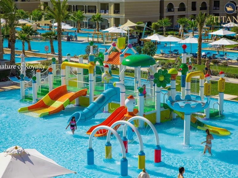 Aire de jeux aquatique colorée avec toboggans et petites piscines dans une station de vacances.