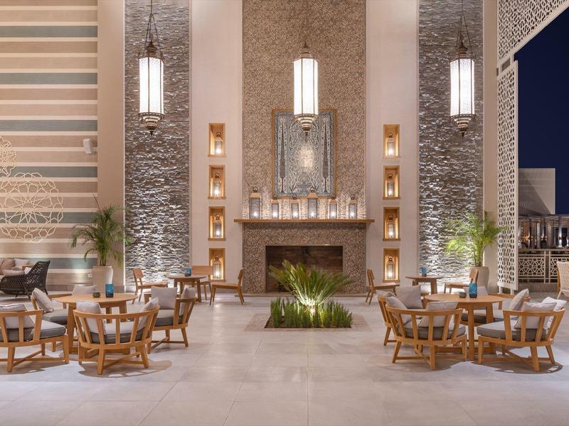 Eleganter Außenbereich mit Kamin, Sitzgruppen und moderner Beleuchtung bei Nacht.