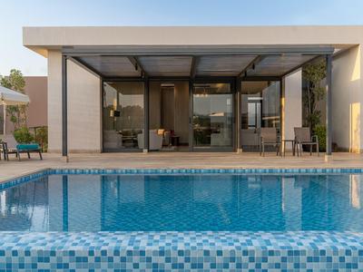 Casa de vacaciones moderna con piscina grande y terraza cubierta.