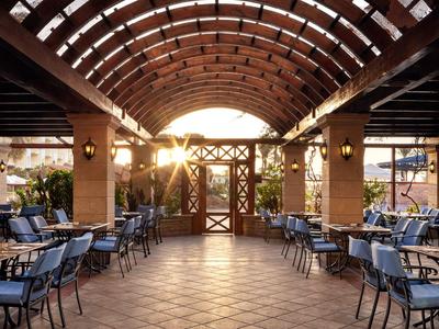 Área de comedor abierta con techo abovedado y luz solar al final de la tarde.